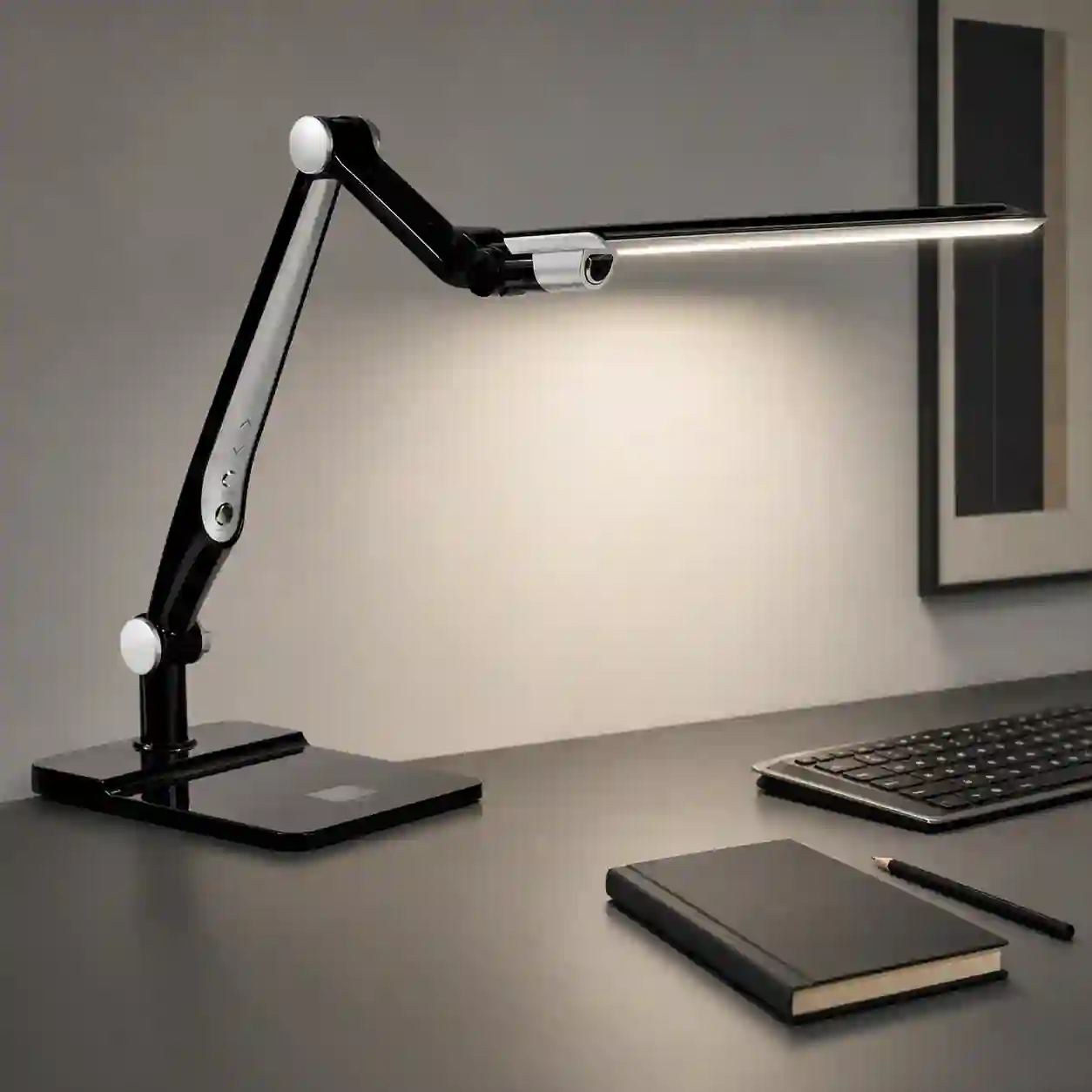 Černá stolní LED lampa GRAFIK s nastavitelným ramenem na pracovním stole